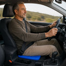 Homem dirigindo com a almofada VittaGel Comfort de gel colmeia azul no banco do carro para mais conforto durante viagens.